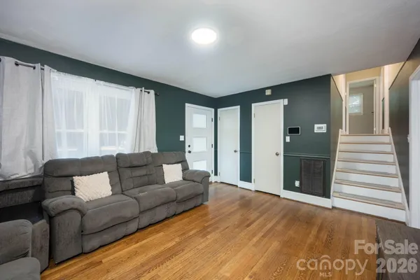 a living room with furniture and a wooden floor