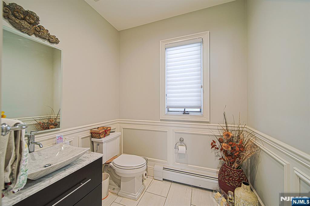 897 Virgil Avenue Ridgefield, NJ 07657 - Photo 26 of 50 a bathroom with a toilet a sink and a window
