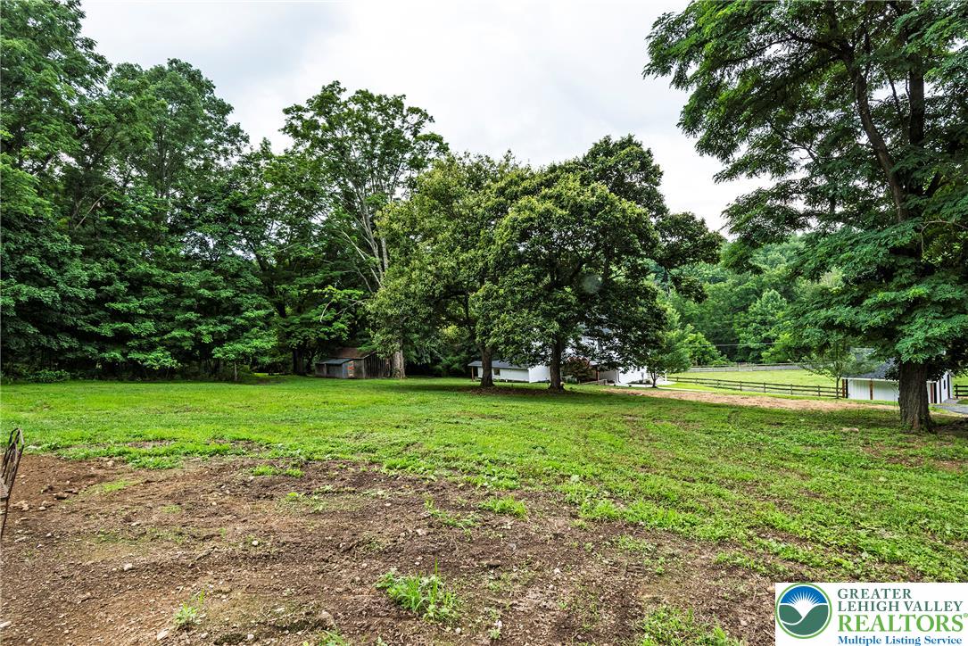 72 Allegheny Road Mount Bethel, PA 18343 - Photo 67 of 72 A tranquil landscape offers a verdant lawn and mature trees, with a secluded residence nestled in the distance.