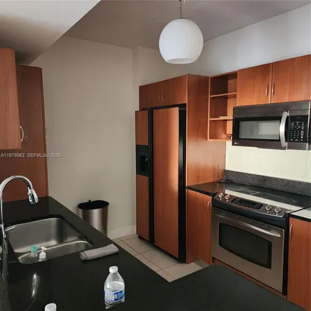 a kitchen with granite countertop stainless steel appliances and wooden cabinets