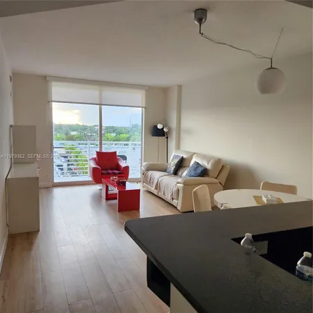a living room with furniture and floor to ceiling window