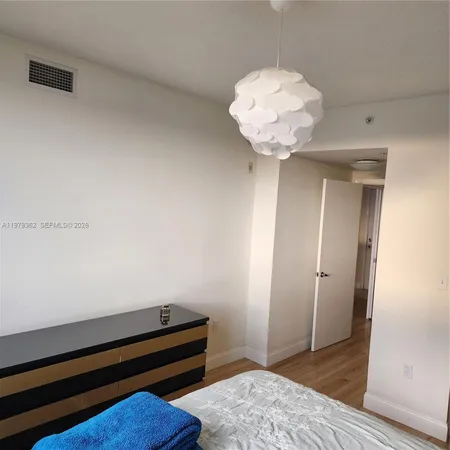 a room with wooden floor and a chandelier