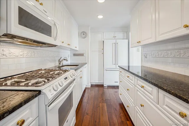 a kitchen with stainless steel appliances granite countertop a stove and a microwave