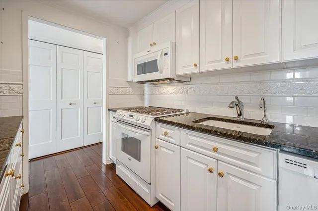 a kitchen with white cabinets and white appliances