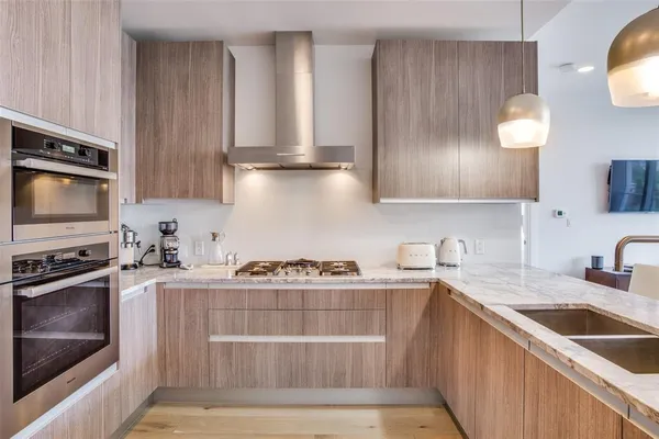 a kitchen with stainless steel appliances granite countertop a sink stove and cabinets