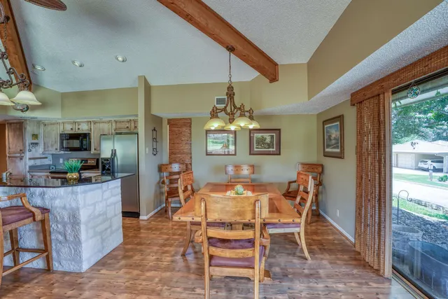 a view of a dining room with furniture a chandelier and wooden floor