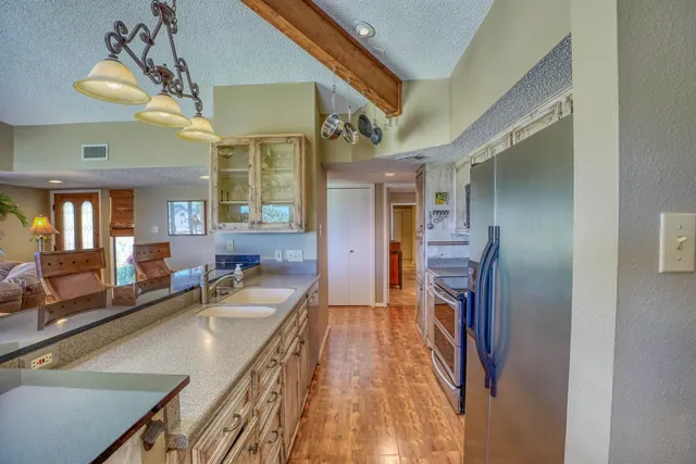 a kitchen that has a lot of cabinets stainless steel appliances and a table