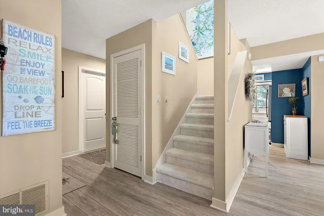 a view of a hallway with wooden floor and entryway