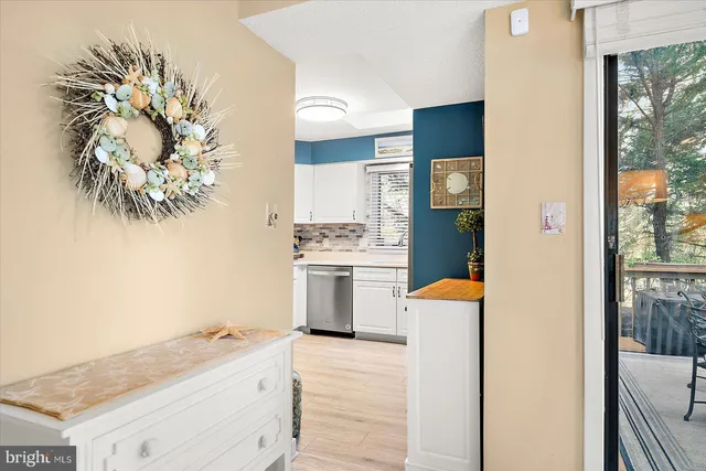 a kitchen with white cabinets and a window