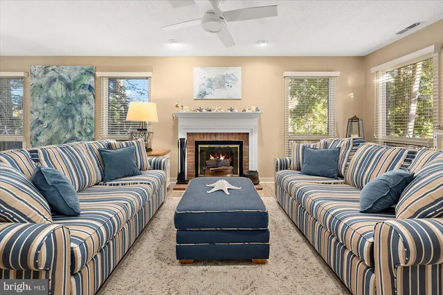 a living room with furniture fireplace and a large window