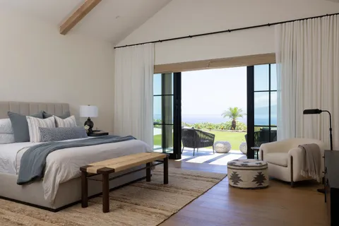 a bedroom with furniture and large windows