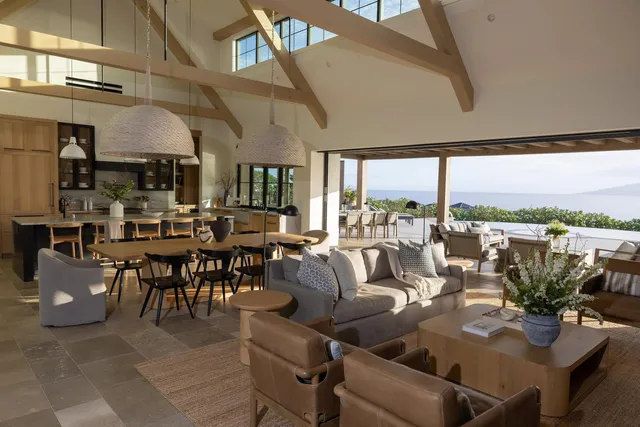 a living room with lots of furniture and a floor to ceiling window