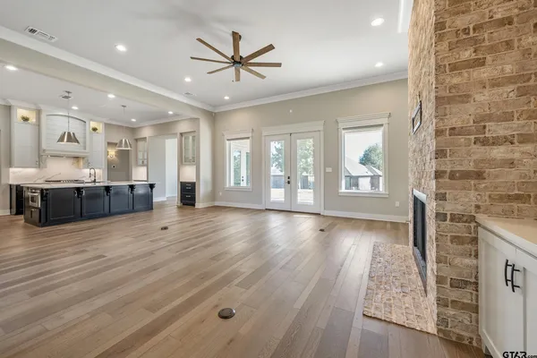 a large kitchen with stainless steel appliances granite countertop a large counter top a stove a sink and a refrigerator