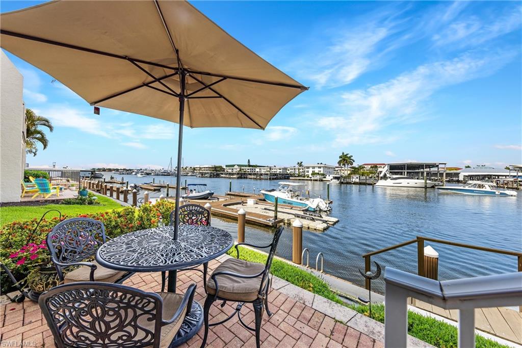 800 River Point Drive, Unit 319 Naples, FL 34102 - Photo 24 of 33 an outdoor space with furniture and umbrella
