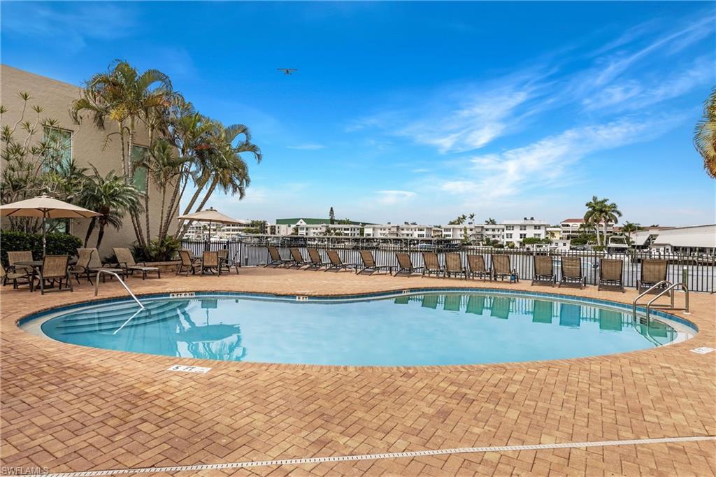 800 River Point Drive, Unit 319 Naples, FL 34102 - Photo 28 of 33 a view of swimming pool with outdoor seating and plants
