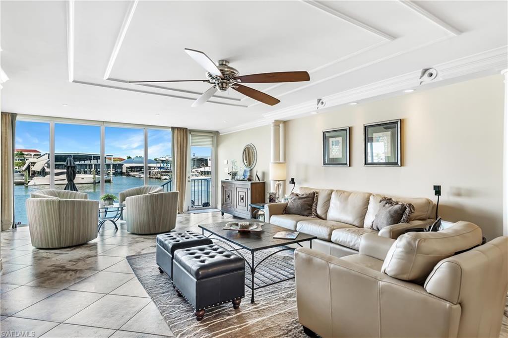 800 River Point Drive, Unit 319 Naples, FL 34102 - Photo 4 of 33 a living room with a couch and a dining table with wooden floor