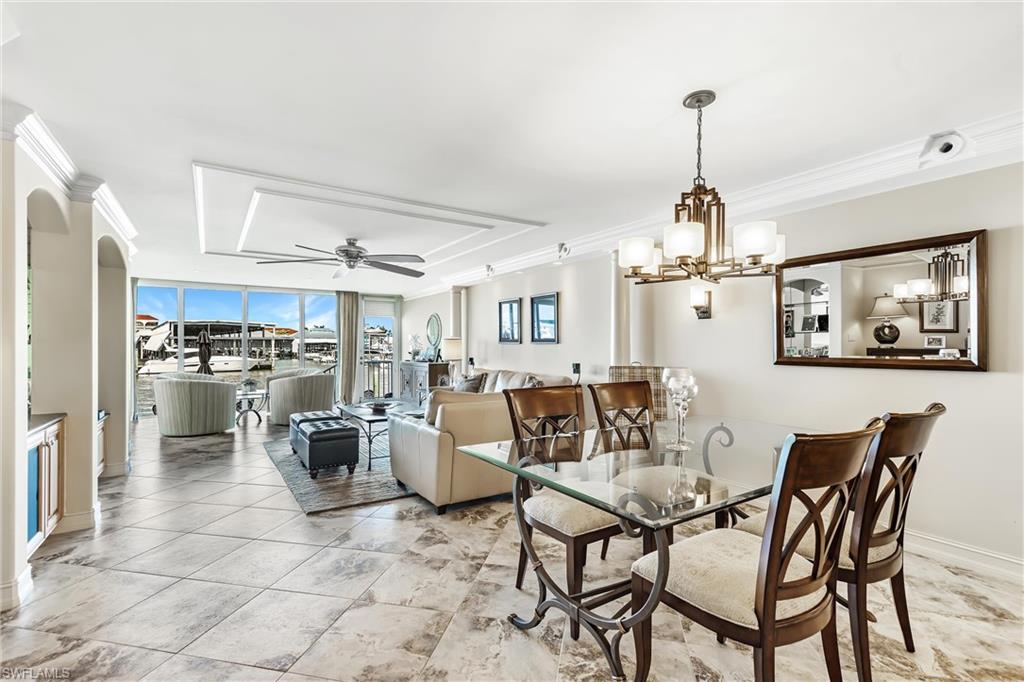 800 River Point Drive, Unit 319 Naples, FL 34102 - Photo 8 of 33 a view of a dining room and livingroom with furniture wooden floor a rug a painting and a chandelier