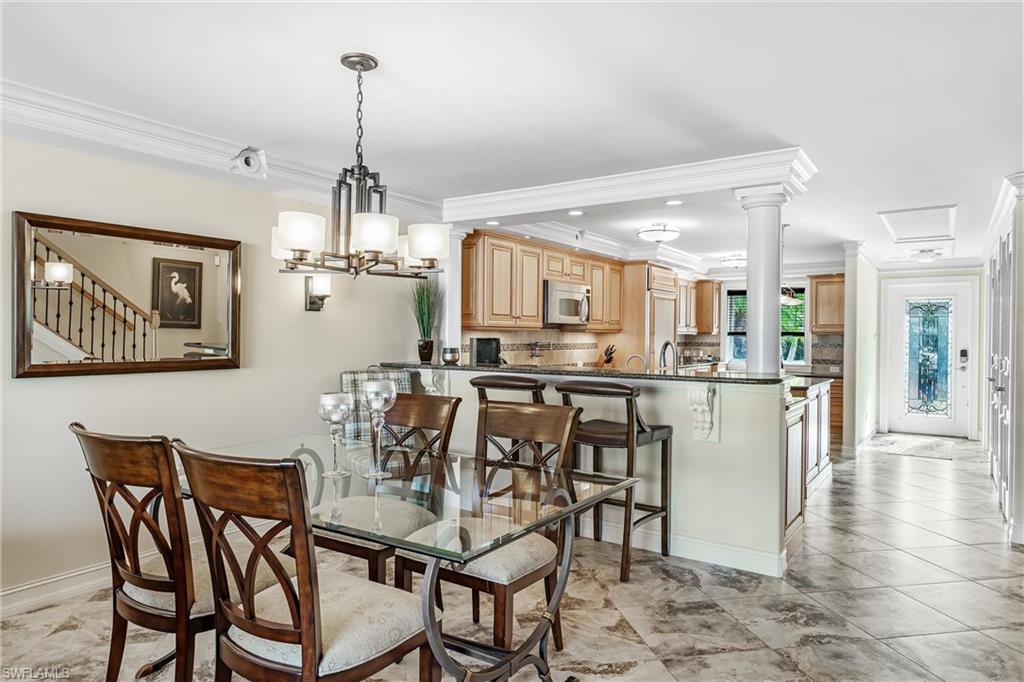 800 River Point Drive, Unit 319 Naples, FL 34102 - Photo 10 of 33 a dining room with stainless steel appliances kitchen island granite countertop a dining table chairs and a refrigerator