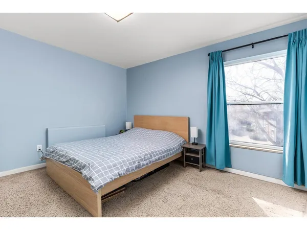 a bed sitting in a bedroom next to a window