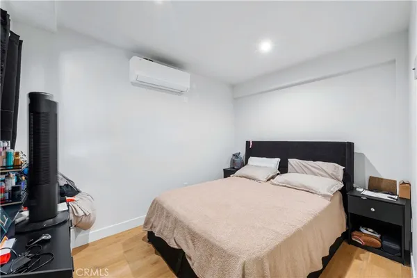 a bedroom with a bed and a flat tv screen on a dresser