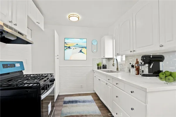 a kitchen with stainless steel appliances a stove a sink and a refrigerator