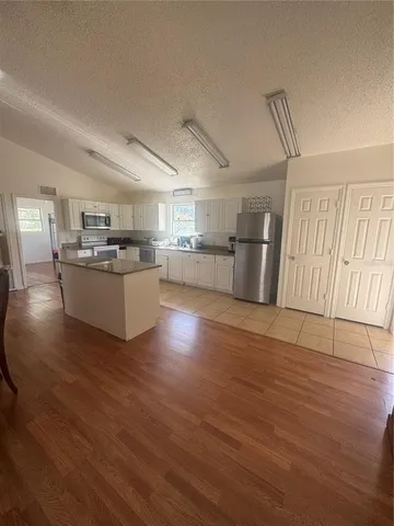 a kitchen with sink and wooden floor