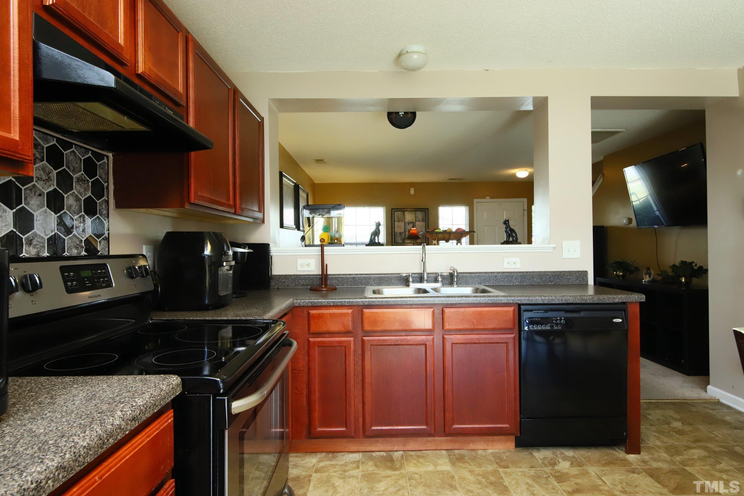 3816 Tryon Ridge Drive Raleigh, NC 27610 - Photo 16 of 28 a kitchen with granite countertop a sink a stove and a wooden cabinets