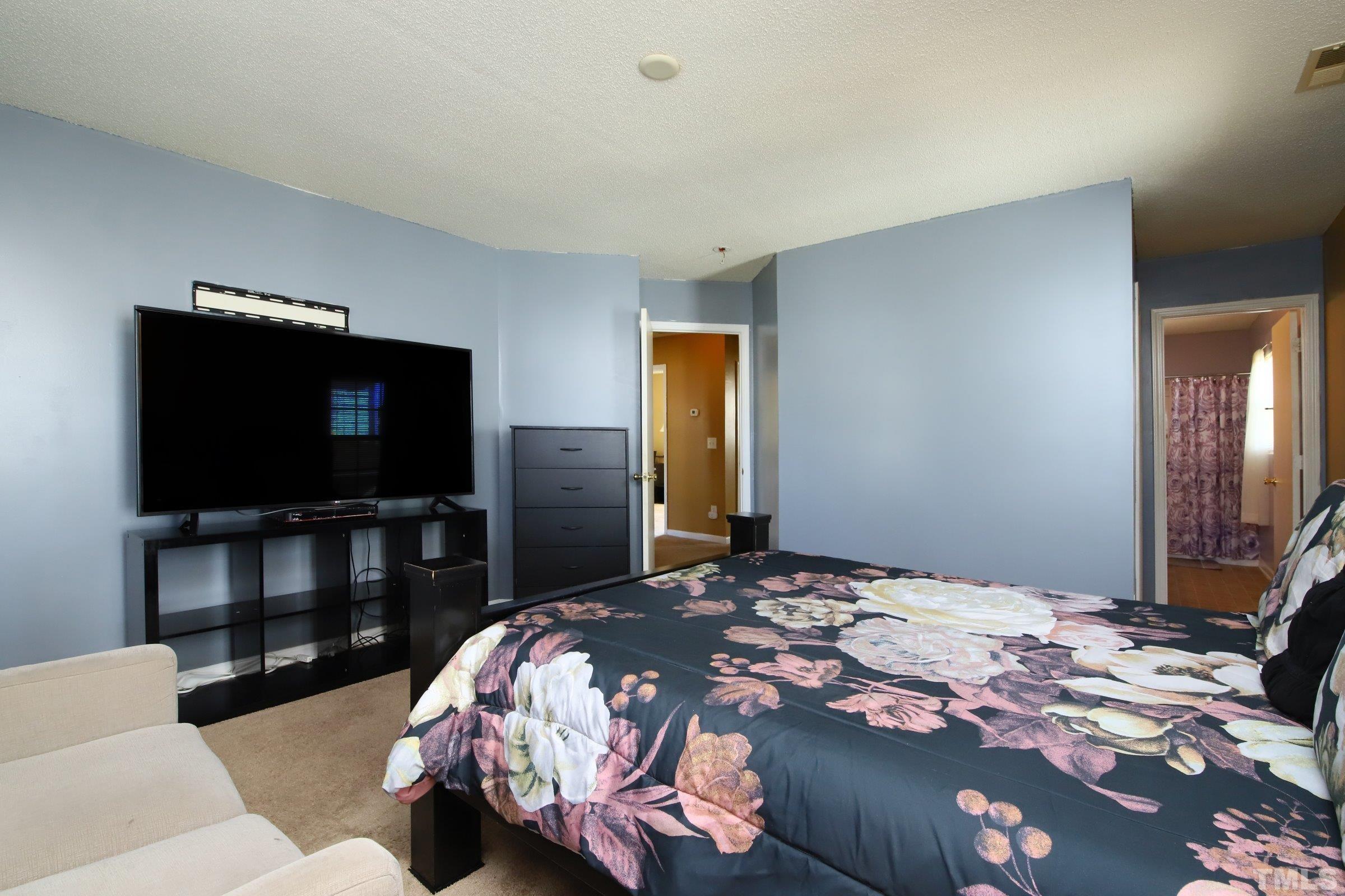 3816 Tryon Ridge Drive Raleigh, NC 27610 - Photo 21 of 28 a bedroom with a bed and a flat screen tv