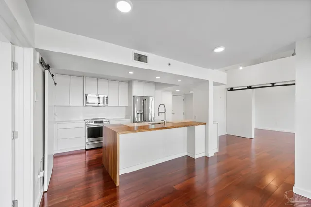 a large open kitchen with a refrigerator and a stove top oven