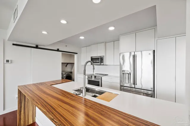 a kitchen with stainless steel appliances a refrigerator and a stove top oven