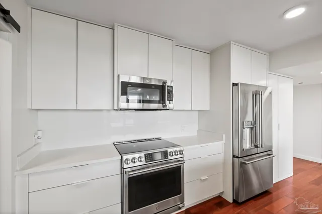 a kitchen with white cabinets and stainless steel appliances