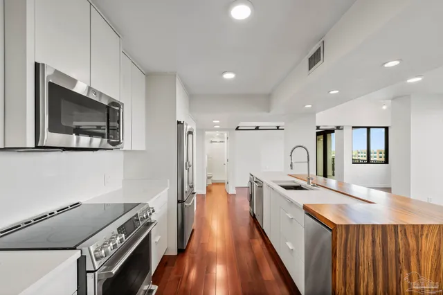 a kitchen with stainless steel appliances granite countertop a lot of counter space and wooden floor