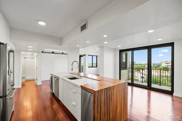 a kitchen with a stove a sink a refrigerator and a large window