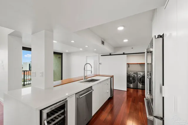 a kitchen with stainless steel appliances granite countertop a sink and a refrigerator