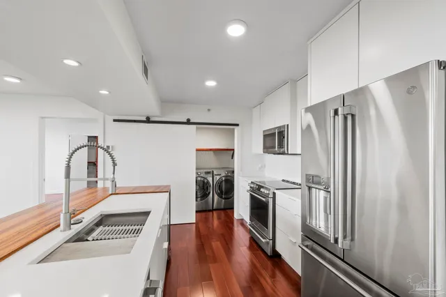 a kitchen with stainless steel appliances granite countertop a refrigerator and a stove top oven