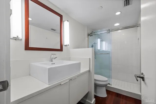 a bathroom with a sink a toilet and shower