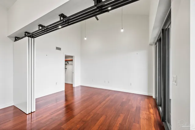 a view of a room with wooden floor and a ceiling fan