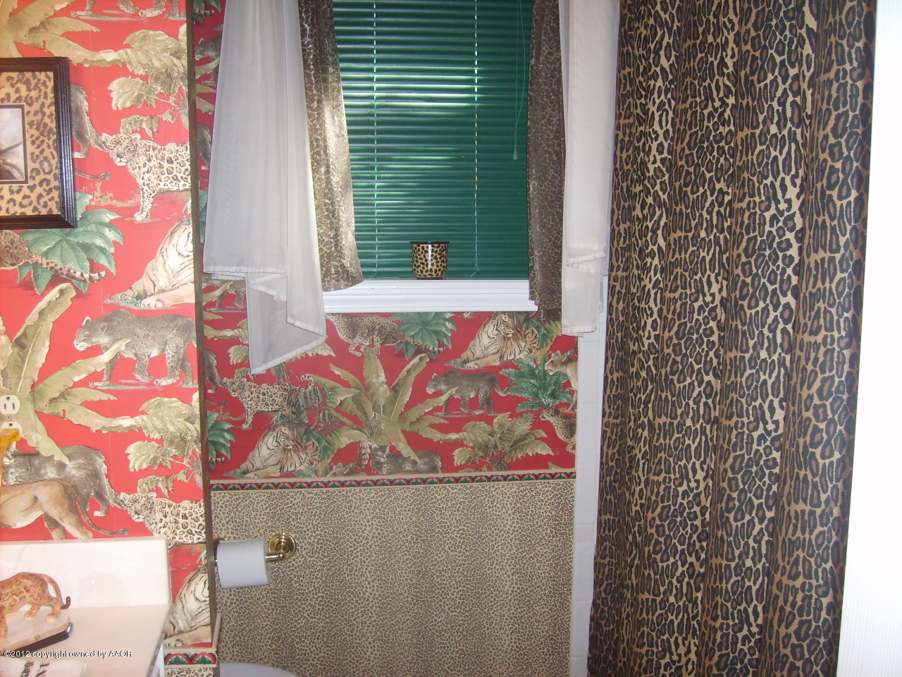 4814 Tulip Avenue Amarillo, TX 79110 - Photo 16 of 27 a bathroom with a painting on the wall and a shower curtain