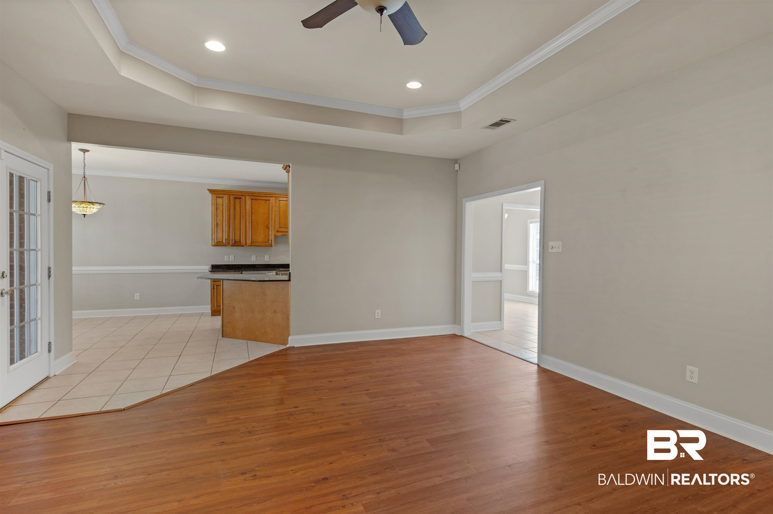 330 Allison Court Mobile, AL 36608 - Photo 5 of 27 Unfurnished living room with ceiling fan, ornamental molding, a raised ceiling, and light wood-type flooring