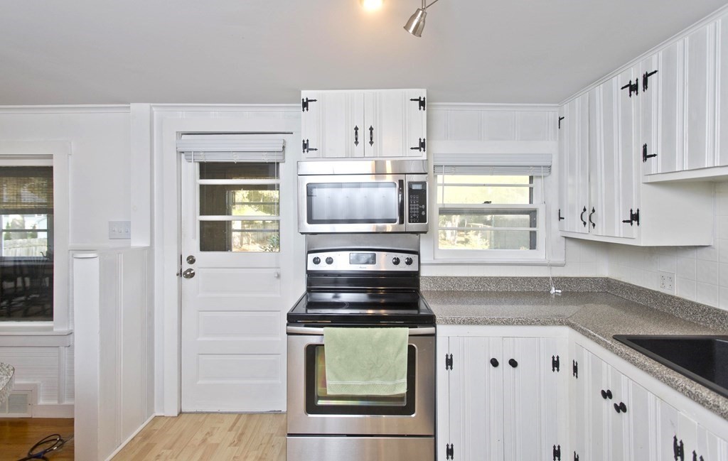 520 Dutchess Street Springfield, MA 01129 - Photo 6 of 31 a kitchen with kitchen island white cabinets and stainless steel appliances