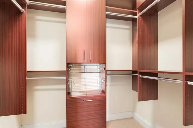 a view of walk in closet with empty racks
