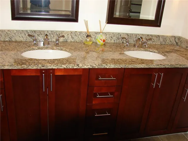 a bathroom with a granite countertop sink and a mirror