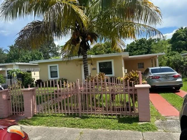 a front view of a house with a garden and tree