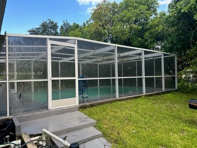 a view of a backyard with floor to ceiling window next to a yard