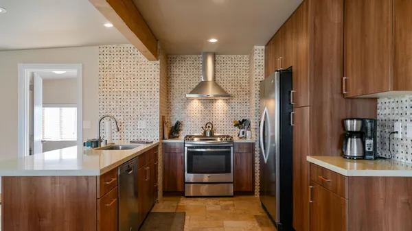 a kitchen with stainless steel appliances granite countertop a sink a stove and a refrigerator