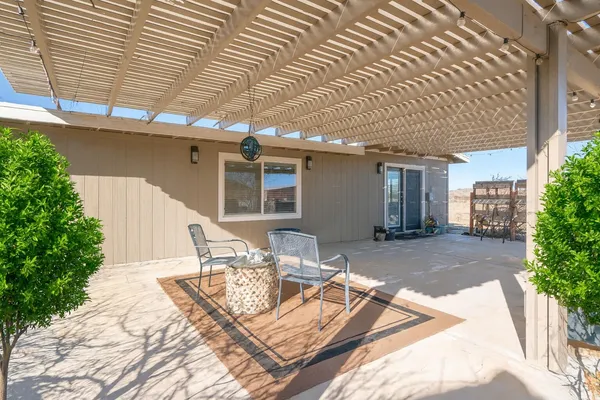 a view of a patio with table and chairs with wooden floor and fence and a potted plant