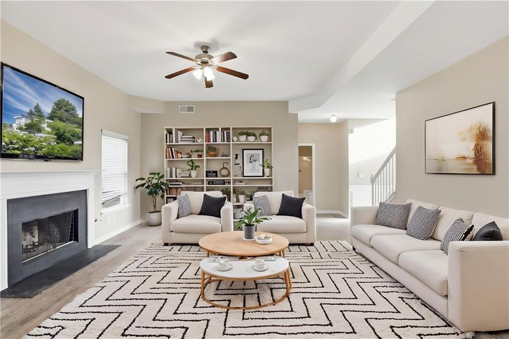 4968 Locherby Drive Fairburn, GA 30213 - Photo 2 of 39 a living room with furniture a rug and a fireplace