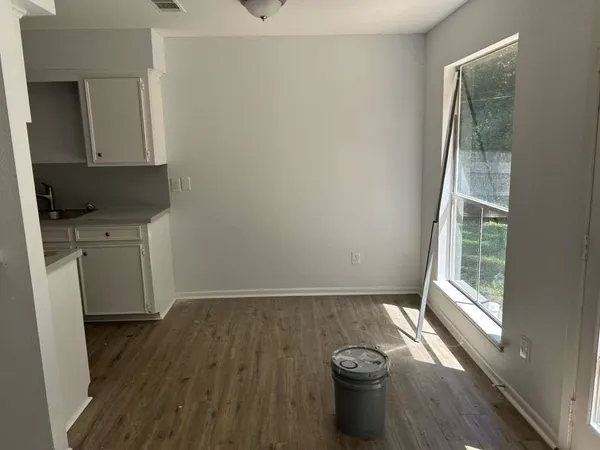 a view of a kitchen with wooden floor and a window