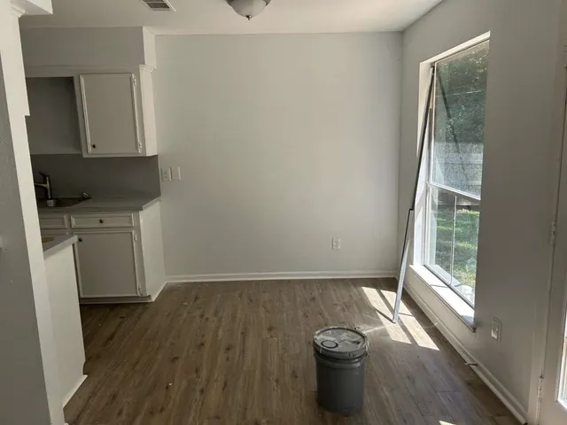 a view of a kitchen with wooden floor and a window