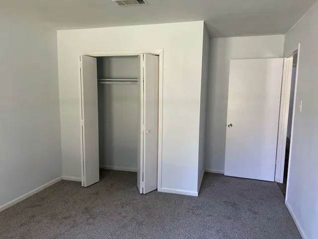 a view of an empty room with closet area